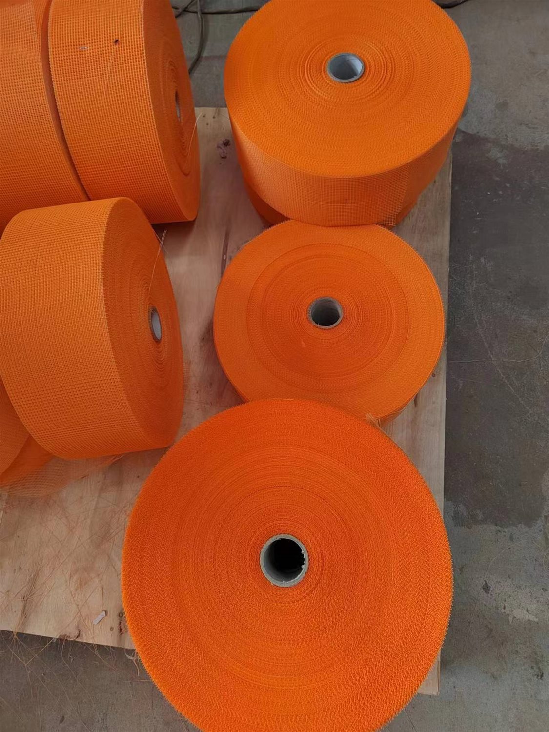 Orange fiberglass mesh rolls viewed from the core